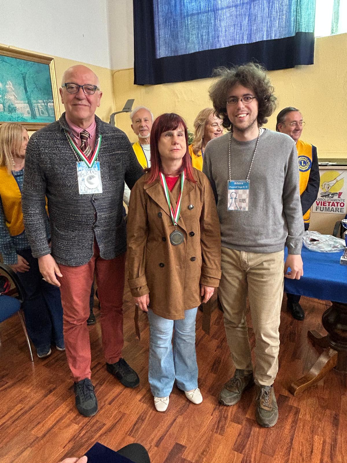 I due arbitri con Lucia micocci al centro. Sullo sfondo si vedono i quattro volontari del Lions Club
