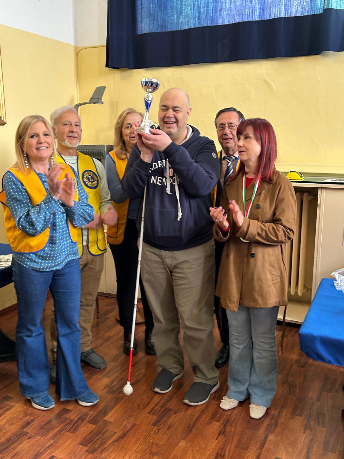 La premiazione di Luca crocioni con la coppa sollevata insieme a Lucia e ai quattro volontari